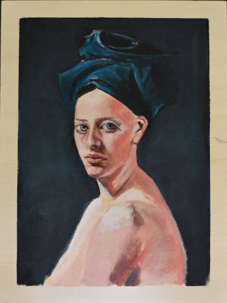 Retrato de mujer con turbante azul oscuro, estudio de piel y mirada directa.